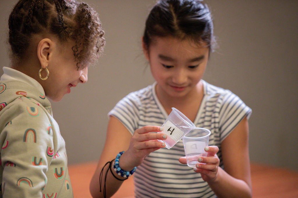 Two students doing an experiment with cups