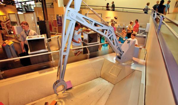 Children operating a crane in the Amazing Machine exhibit at The Franklin Institute.