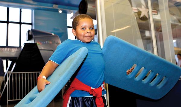 A boy using the foam wings interactive in the Franklin Airshow exhibit at The Franklin Institute.