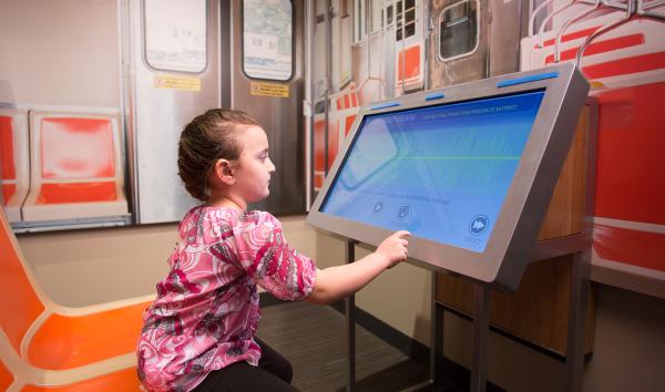 A young girl using the Say That Again interactive in the Your Brain exhibit at The Franklin Institute.