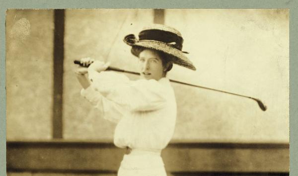 A woman swinging a golf club.