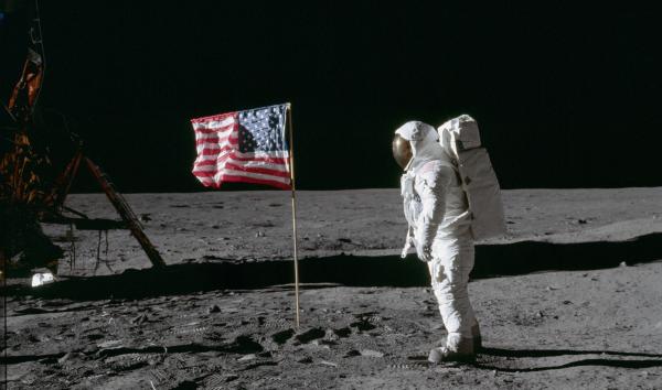 astronaut on moon with American Flag