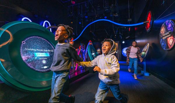 boys running through space exhibit