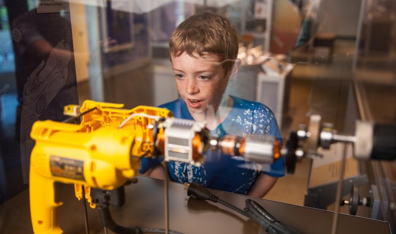 Young boy looking at machine exhibit