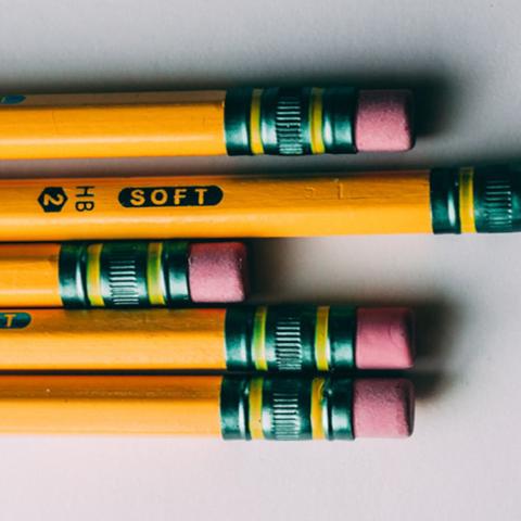 Photo of yellow pencils with pink erasers on the ends