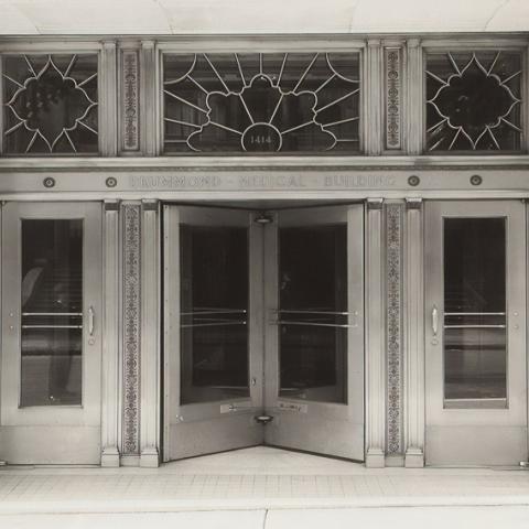 Photograph of front of a building with a set of revolving doors