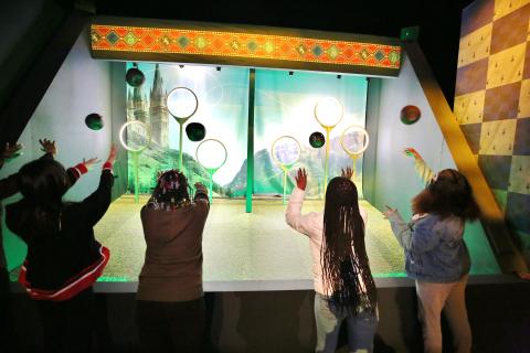 teens throwing quidditch balls through loops