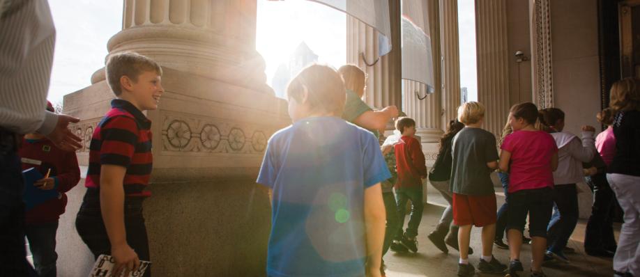 Visitors entering the museum's front doors at sunrise.