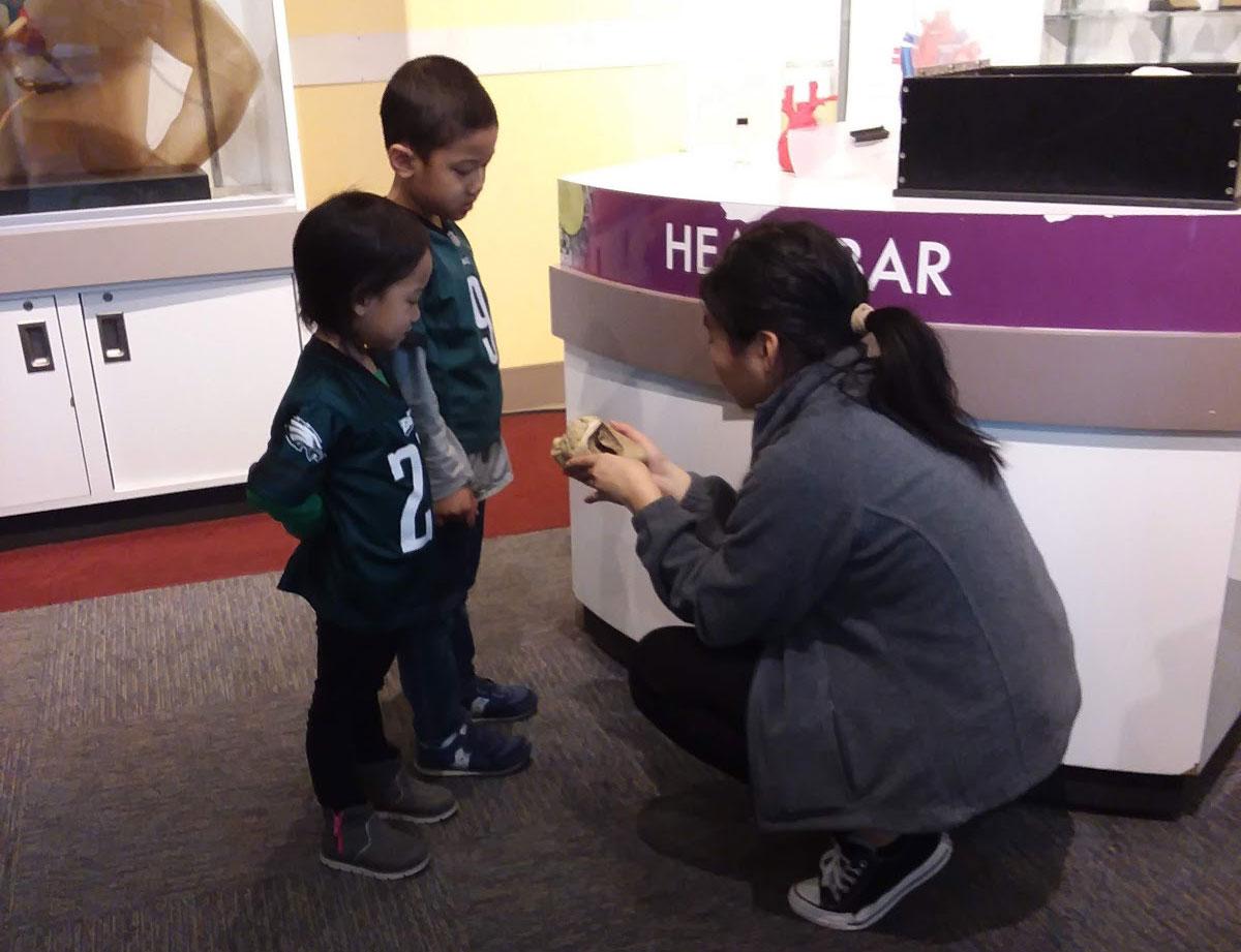Volunteer Jessica Zhoa gives a demonstration to visitors at the Heart Bar at The Franklin Institute