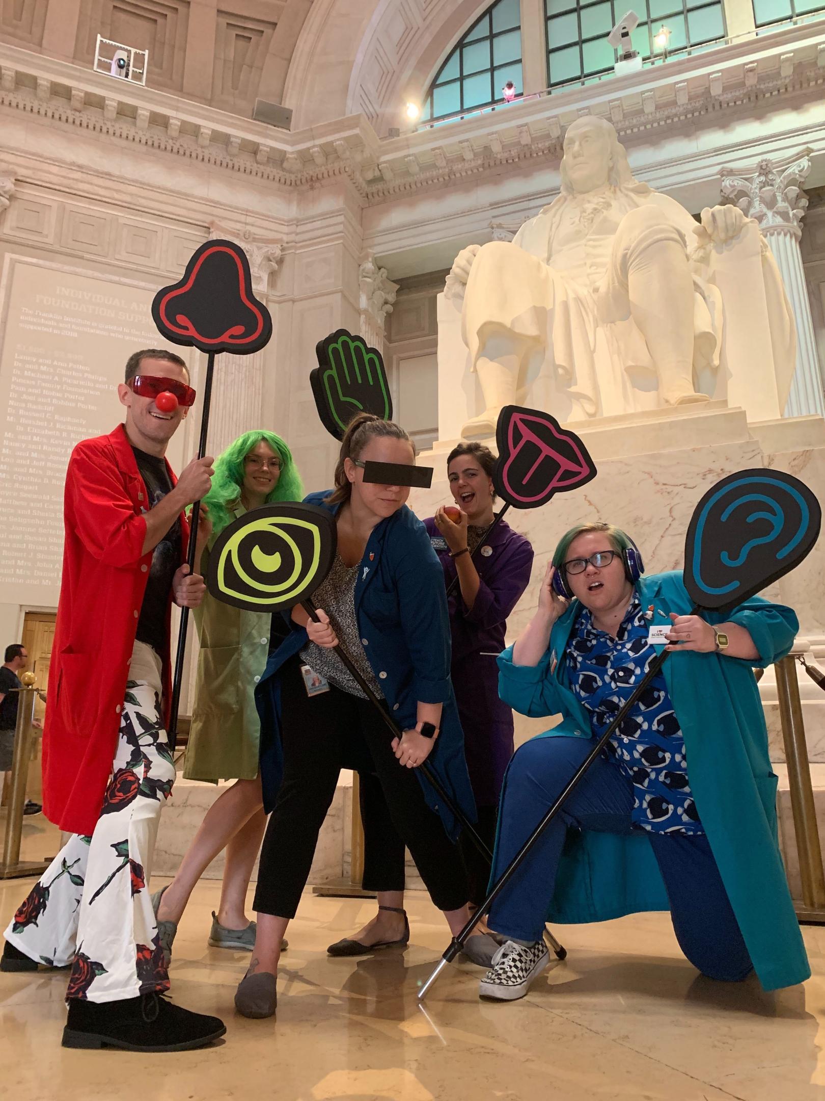 Science Interpreters holding totems for Science After Hours Sci-Chella