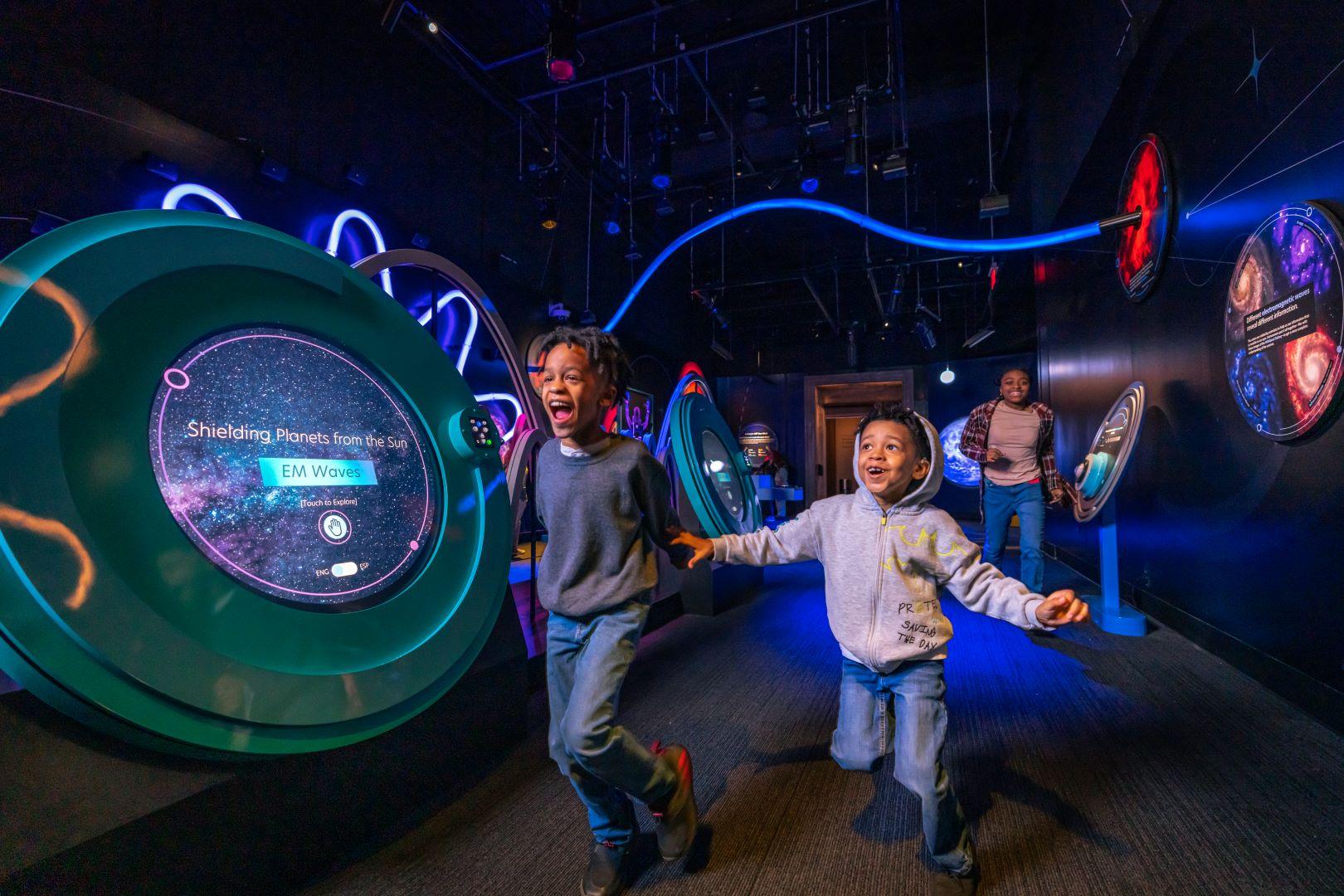 Boys running through exhibit space